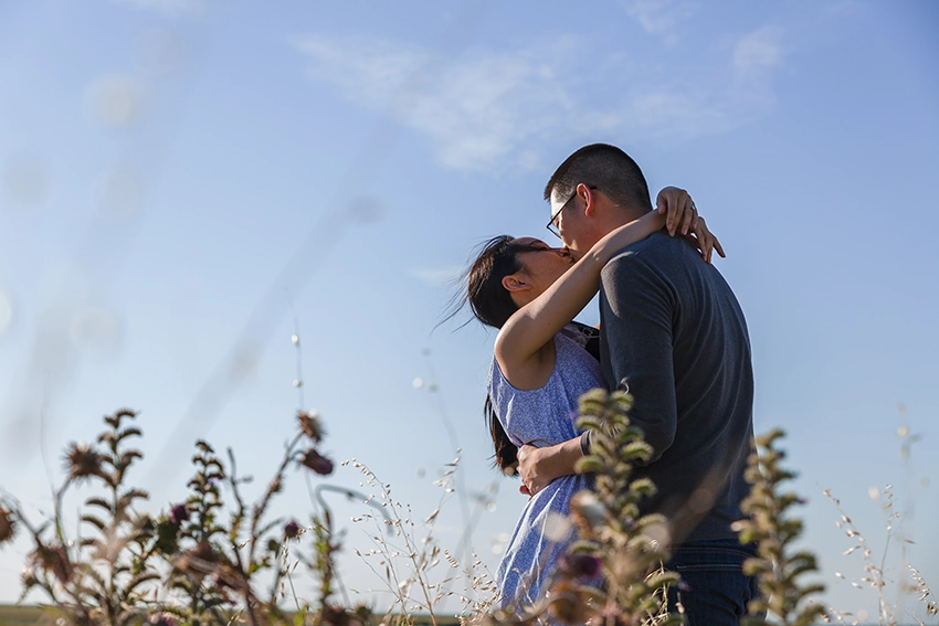 Couple s’embrassant dans les prés du Mont-Saint-Michel en contre-jour — séance photo couple fiançailles Normandie